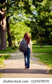 Rear View Of A Female Student With A Backpack, Walking In Park La Fontaine In Montreal Quebec Canada On A Bright Sunny Day