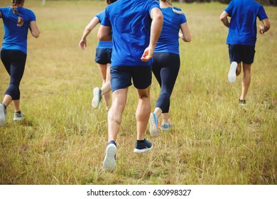 Rear view of fit people running in boot camp