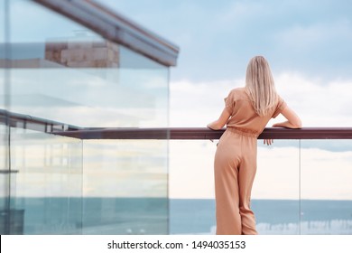 Rear view of fit unidentified young woman tourist admiring magnificent view from hotel terrace to the sea and the horizon. Beautiful woman admires the view after the long-awaited arrival on vacation - Powered by Shutterstock