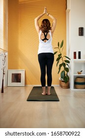 Rear View Of Fit Yogi Woman Standing On The Mat In Her Home Crescent Moon Yoga Pose.