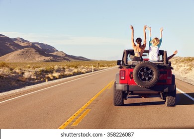 Rear View Of Friends On Road Trip Driving In Convertible Car - Shutterstock ID 358226087