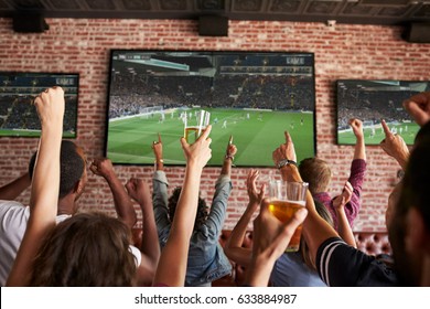 Rear View Of Friends Watching Game In Sports Bar On Screens - Powered by Shutterstock