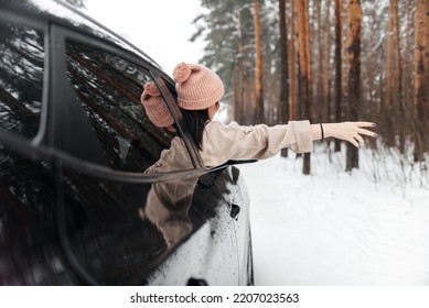 Rear View Of Girl In Car Over Snowy Forest On Winter Roadtrip