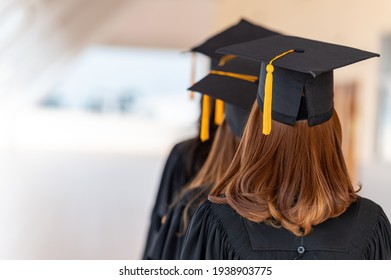 Rear View Of Graduated Student In Academic Gown And Graduation Cap