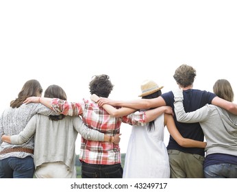 Rear view of group of friends hugging. Horizontal.