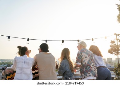 Rear View Of Group Friends At The Party In Top Of The Roof 