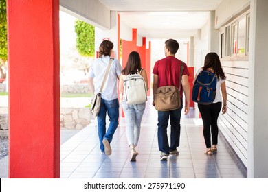 Rear View Of A Group Of University Students Walking Away On A School Hallway