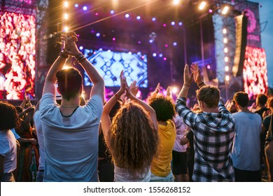 Rear View Of Group Of Young Friends Dancing At Summer Festival.