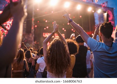 Rear view of group of young friends dancing at summer festival. - Shutterstock ID 1668006763