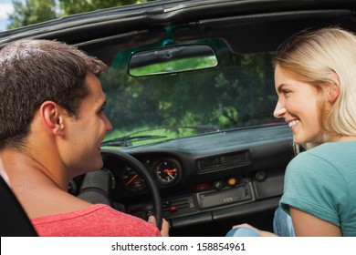 Rear view of happy couple in cabriolet on a sunny day - Powered by Shutterstock