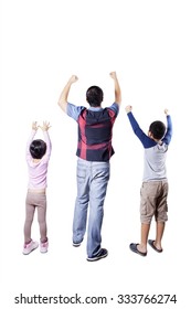 Rear view of happy young father and his children standing in the studio and raise hands together