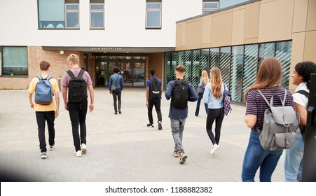Rear View Of High School Students Walking Into College Building Together
