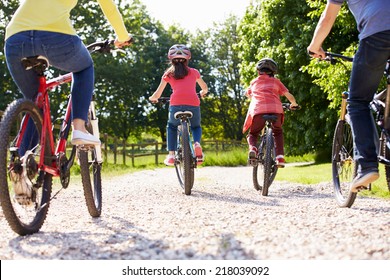 Rear View Of Hispanic Family On Cycle Ride In Countryside