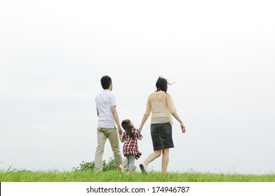 Rear View Of Japanese Family Walking Riverbed