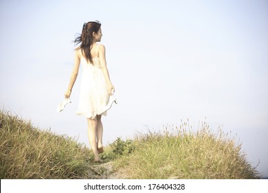 Rear View Of A Japanese Woman Walking Barefoot