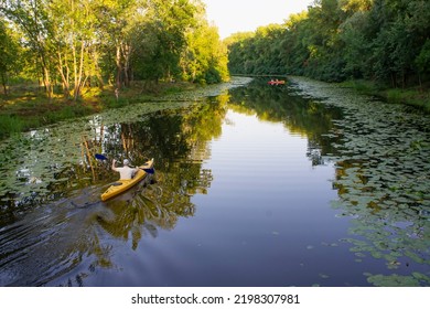 Rear view of kayaker man paddle kayak at sunset river. Kayaking, canoeing, paddling