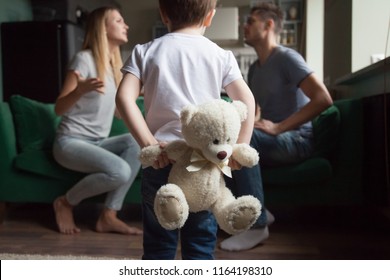 Rear view at kid boy holding toy while parents fighting, little son suffering from parents arguments, lack of attention or divorce, bad family relationships and psychological impact on child concept - Powered by Shutterstock