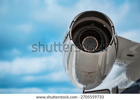 Rear view of the left engine on a Gulfstream 260 business jet, photographed from below in a close-up technical angle, with soft-focus blue sky in the background.