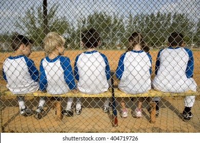 Rear view little league baseball team sitting on bench - Powered by Shutterstock