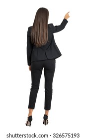 Rear View Of Long Dark Hair Beauty Pointing Or Presenting On Her Right Side. Full Body Length Portrait Isolated Over White Studio Background. 