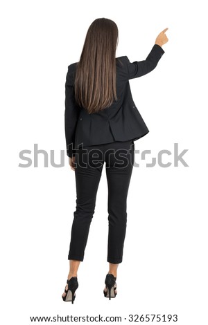 Rear view of long dark hair beauty pointing or presenting on her right side. Full body length portrait isolated over white studio background. 