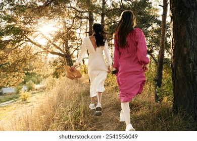 Rear view. Lovely lesbian couple are together outdoors in nature. - Powered by Shutterstock