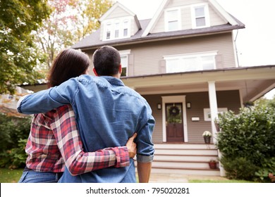 Rear View Of Loving Couple Looking At House