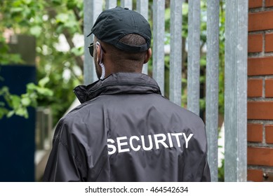 Rear View Of A Male Security Guard Wearing Black Uniform