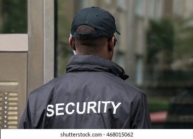 Rear View Of A Male Security Guard Wearing Black Uniform