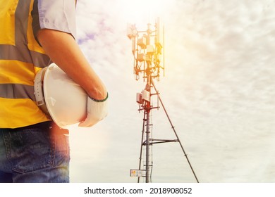 Rear View Male Technician Engineers Wearing Safety Protective Clothing Work High Tower Telecommunication Antennas Installed On Buildings For Construction, Installation And General Maintenance Work.