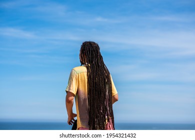 Rear view of man with dreadlocks looking at the sky