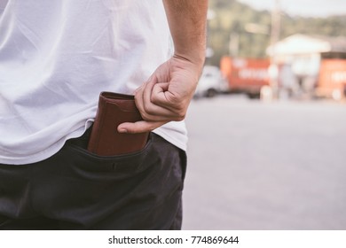 Rear View Of Man Keeping Wallet In Back Pocket Of His Chino Pant