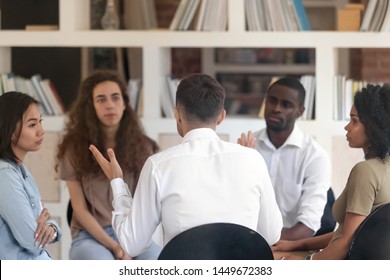 Rear View Man Sharing Problems With Diverse Group At Therapy Session, Male Therapist, Psychologist Speaking With Patients At Meeting, Addiction Treatment, Coach Training Staff, Team Building Activity