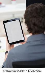 Rear View Of A Man Sitting Down And Looking At A Tablet PC With White Blank Screen