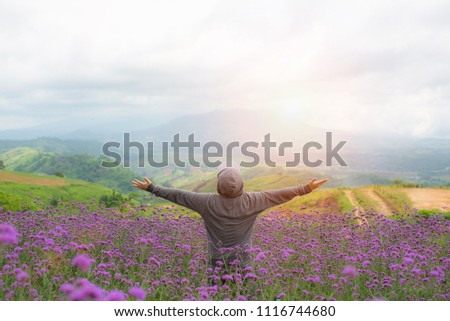 Rear view of man spreading arms in meadow of lavender. Emotional scene,copy space.