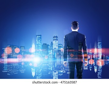 Rear View Of Man In Suit Looking At Cityscape And Its Reflection. Concept Of Large Business Corporation And Endless Opportunities. Toned Image