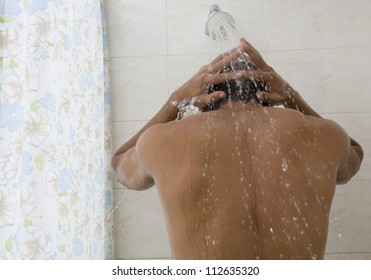 Rear view of a man taking a shower