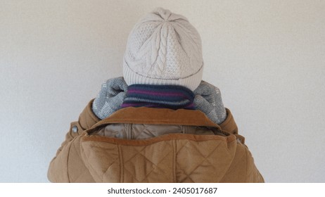 Rear view of a man wearing a beanie, scarf, and coat. - Powered by Shutterstock