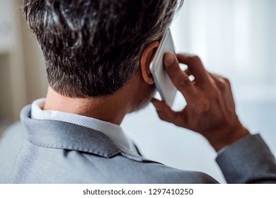 A Rear View Of Mature Businessman With Smartphone Making A Phone Call.