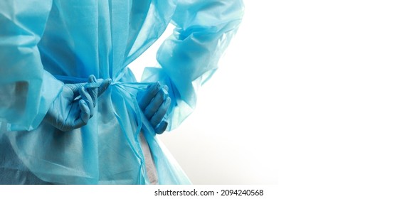 Rear view of a medical worker wearing a  protective medical suit to protect against coronavirus. Copy space in banner size. - Shutterstock ID 2094240568