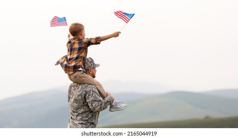 Rear View Of Military Man Father Carrying Happy Little Son With American Flag On Shoulders And Enjoying Amazing Summer Nature View On Sunny Day, Happy Male Soldier Dad Reunited With Son After US Army