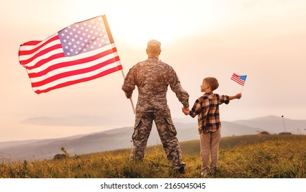 Rear view of military man father holding   son's hand   with american flag   and enjoying amazing summer nature view on sunny day, happy male soldier dad reunited with son after US army - Powered by Shutterstock