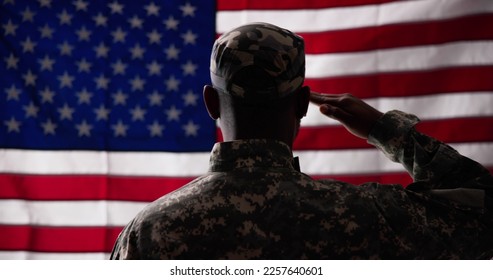 Rear View Of Military Man Saluting Us Flag - Powered by Shutterstock