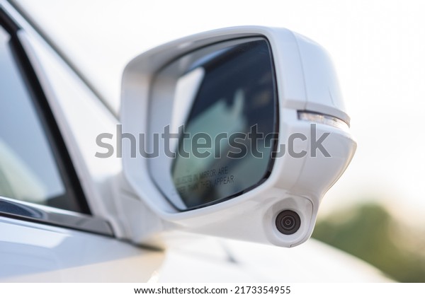 Rear view mirror cover with surround view 360\
degrees camera. A camera system on right side mirror on car to help\
drivers can see a blind spot area. Parking assistance technology\
and car help systems.