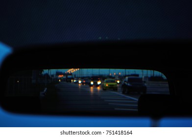 Rear View Mirror Show Blurred A Cars On The Road At Night.