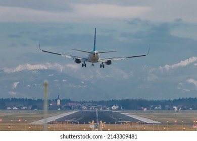 Rear view of modern twin jet engine descending from the clouds. Low flying passenger jet liner ready to land on an airport of Ljubljana, Slovenia. - Shutterstock ID 2143309481