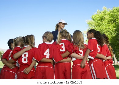 Rear view of multi ethnic football players with coach standing in the front - Powered by Shutterstock