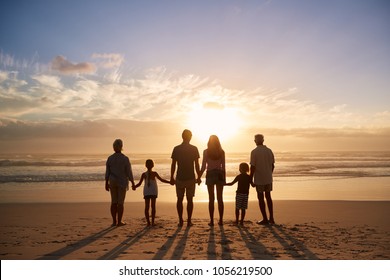 Rear View Of Multi Generation Family Silhouetted On Beach - Shutterstock ID 1056219500
