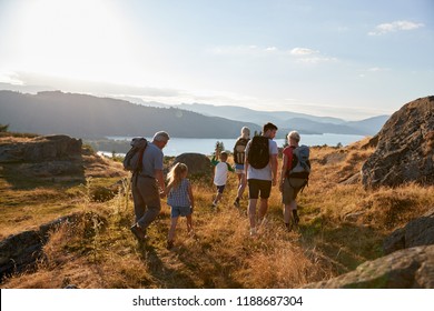 Rear View Of Multi Generation Family Walking On Top Of Hill On Hike Through Countryside In Lake District UK