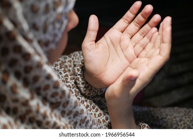 Rear View Of Muslim Women Hand Praying At Night 